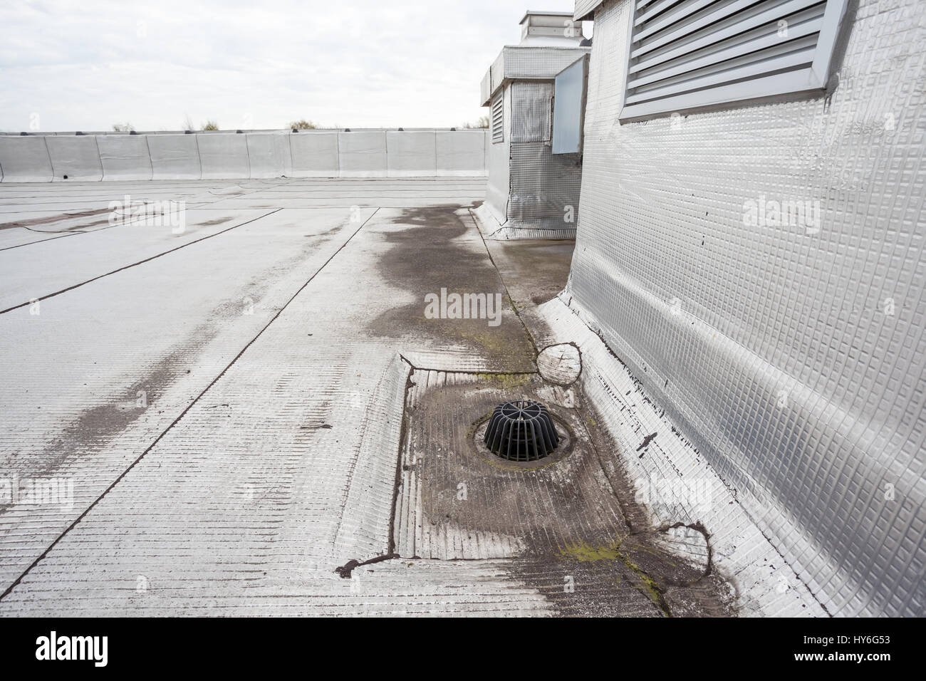 auf ein Flachdach ist Abfluss, um gegen Blätter halten Stockfoto