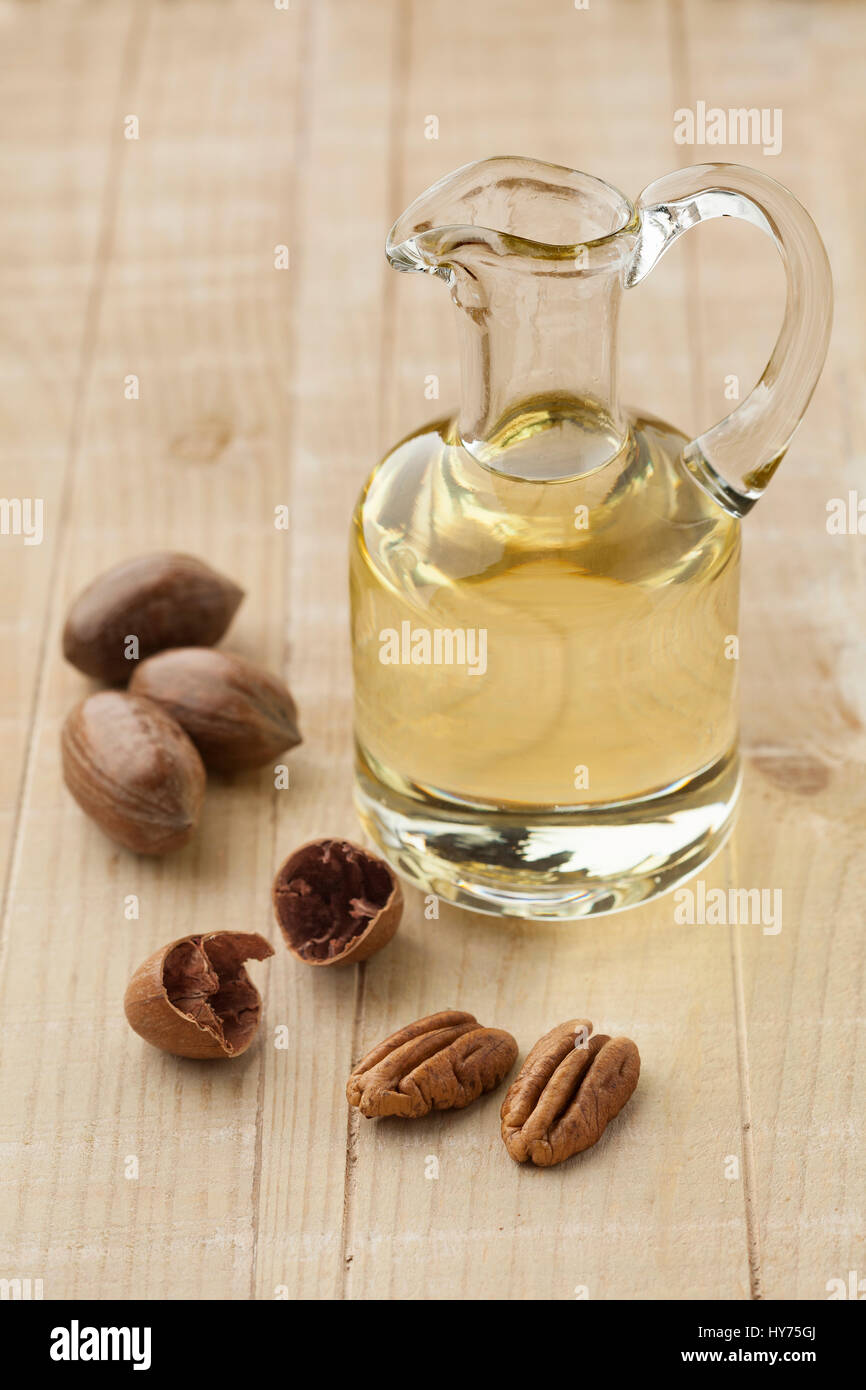 Glas kann mit Pekannuss-Öl und Nüssen Stockfoto