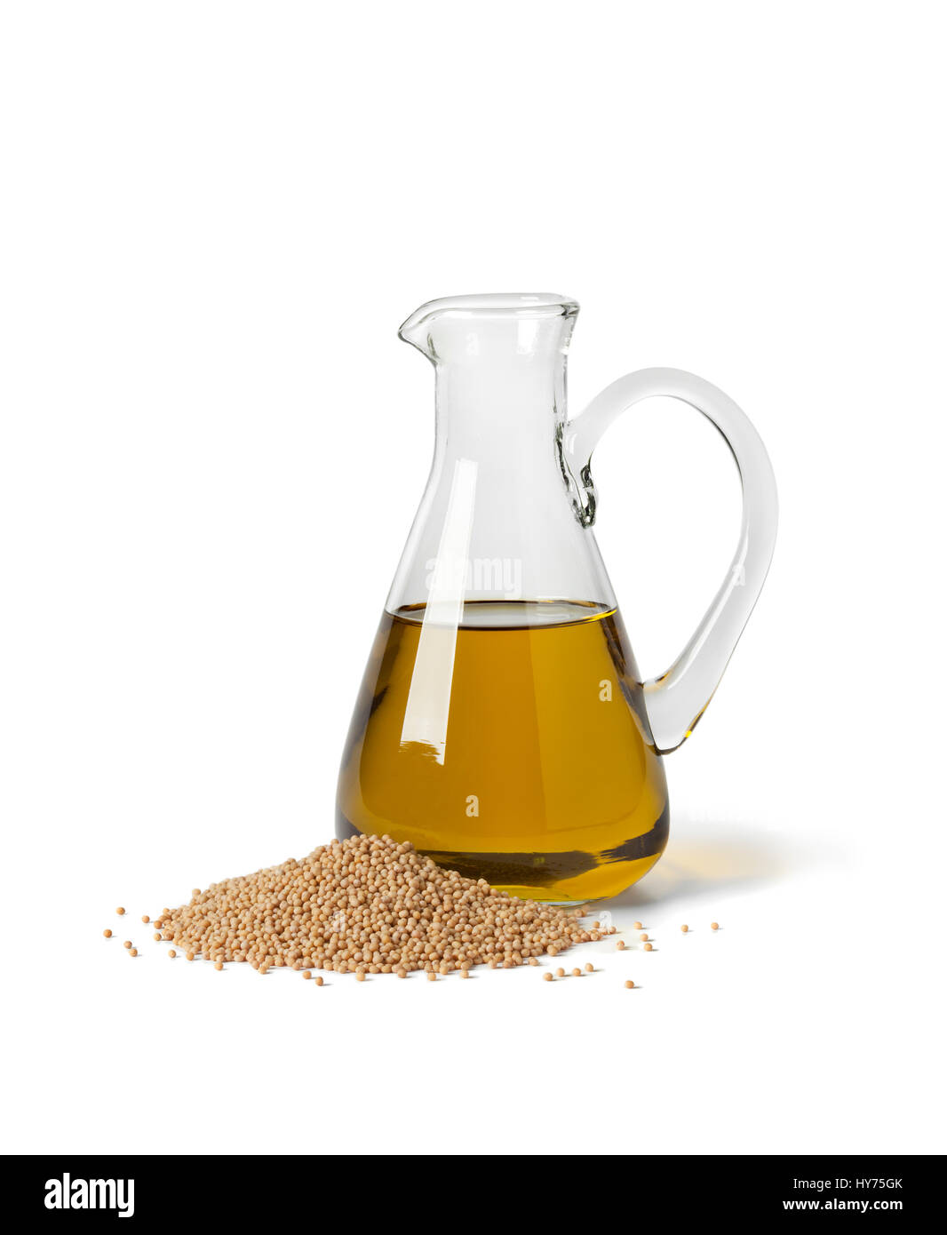 Glasflasche mit Senföl und ein Haufen von Samen auf weißem Hintergrund Stockfoto
