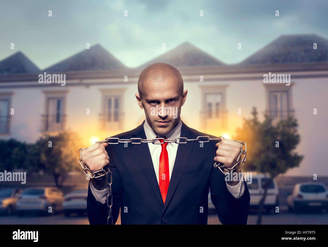 Stiller Killer mit Eisenkette in Hände Tapeten, Hintergrund oder Plakat Konzept. Attentäter in Anzug und roter Krawatte. Professionelle Geheimagenten. Schalldämpfer-Mann Stockfoto