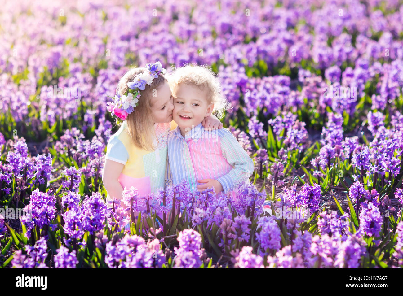 Kinder im Garten. Kinder spielen im Freien auf Hyazinthen Wiese. Kleine Mädchen und jungen, Bruder und Schwester, arbeiten im Garten, Hyazinthe Blumen Pflanzen, wa Stockfoto