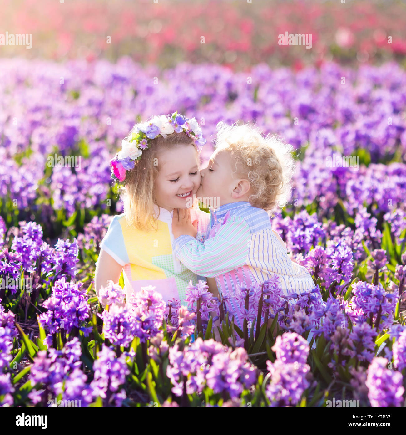 Kinder im Garten. Kinder spielen im Freien auf Hyazinthen Wiese. Kleine Mädchen und jungen, Bruder und Schwester, arbeiten im Garten, Hyazinthe Blumen Pflanzen, wa Stockfoto