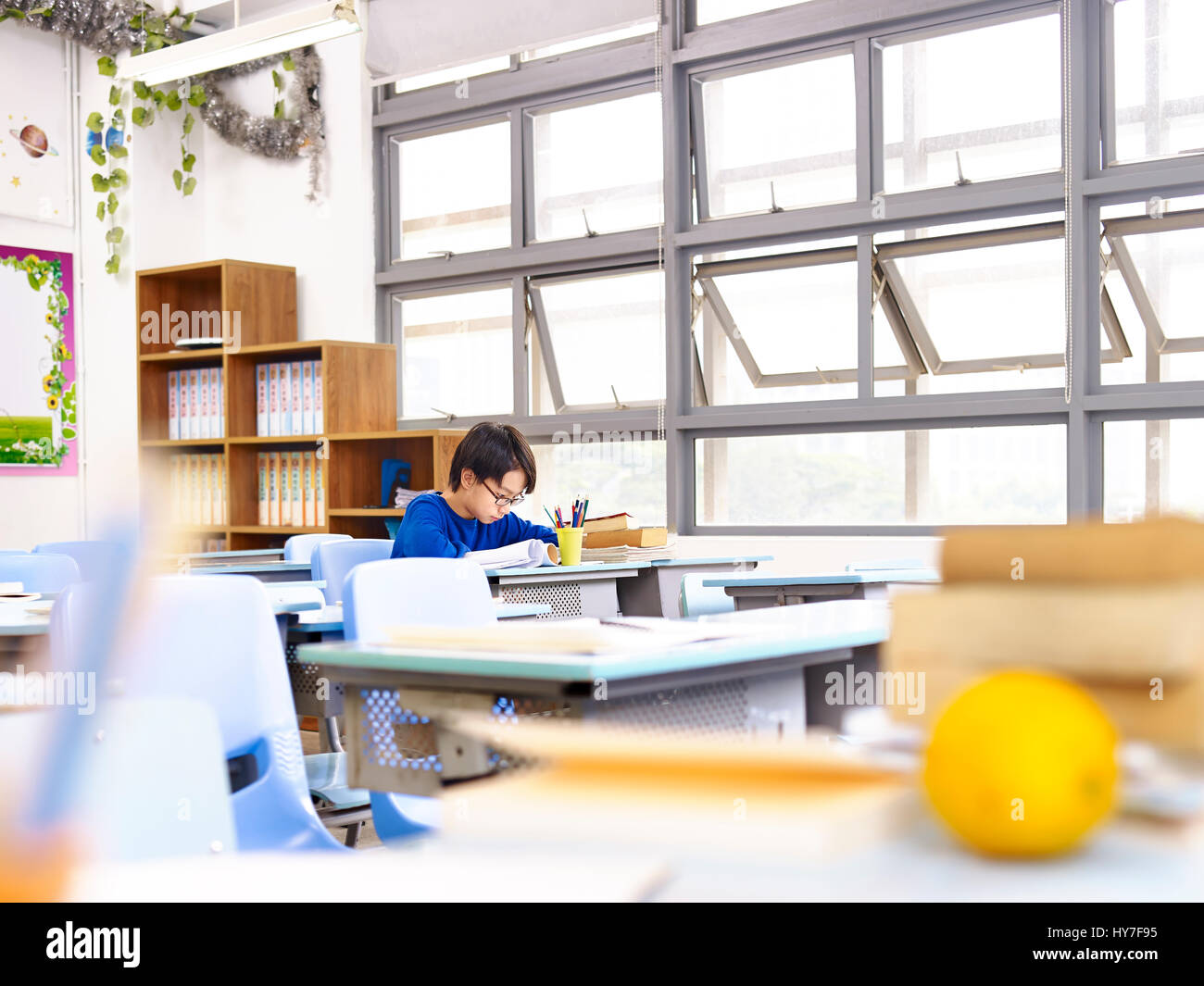 asiatische Schuljunge allein im Klassenzimmer zu studieren. Stockfoto