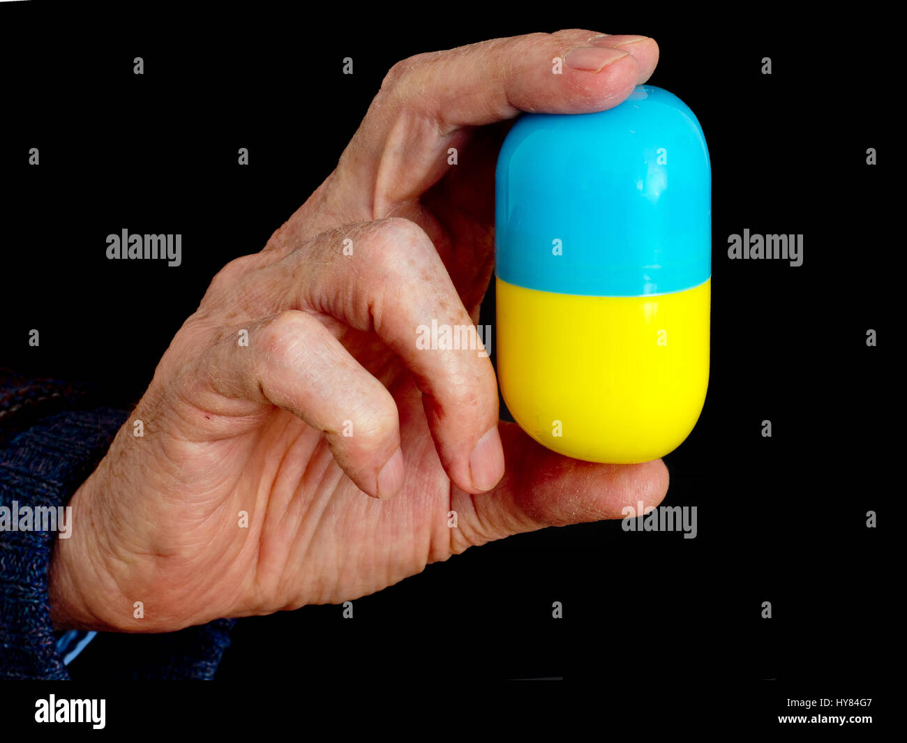 Bittere Pille zu schlucken. Konzept, Metapher. Hände des älteren Mannes. Stockfoto