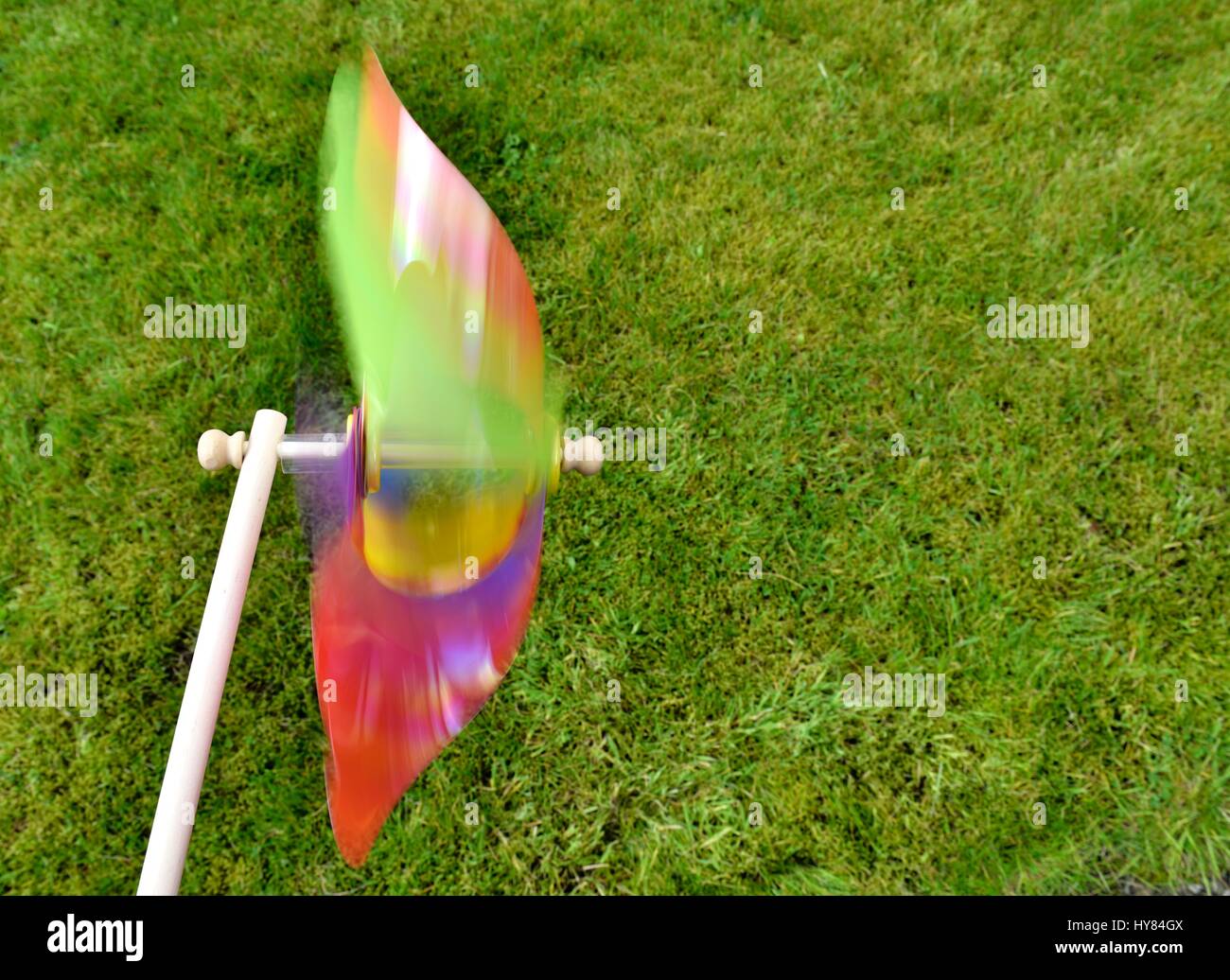 Buntes Spielzeug Windmühle im Hintergrund Rasen. Stockfoto