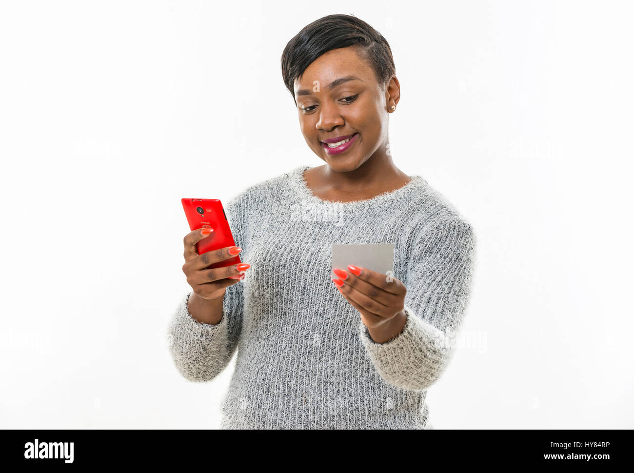 Eine Afrikanerin benutzt ein Handy in einem Studio-Umfeld. Stockfoto