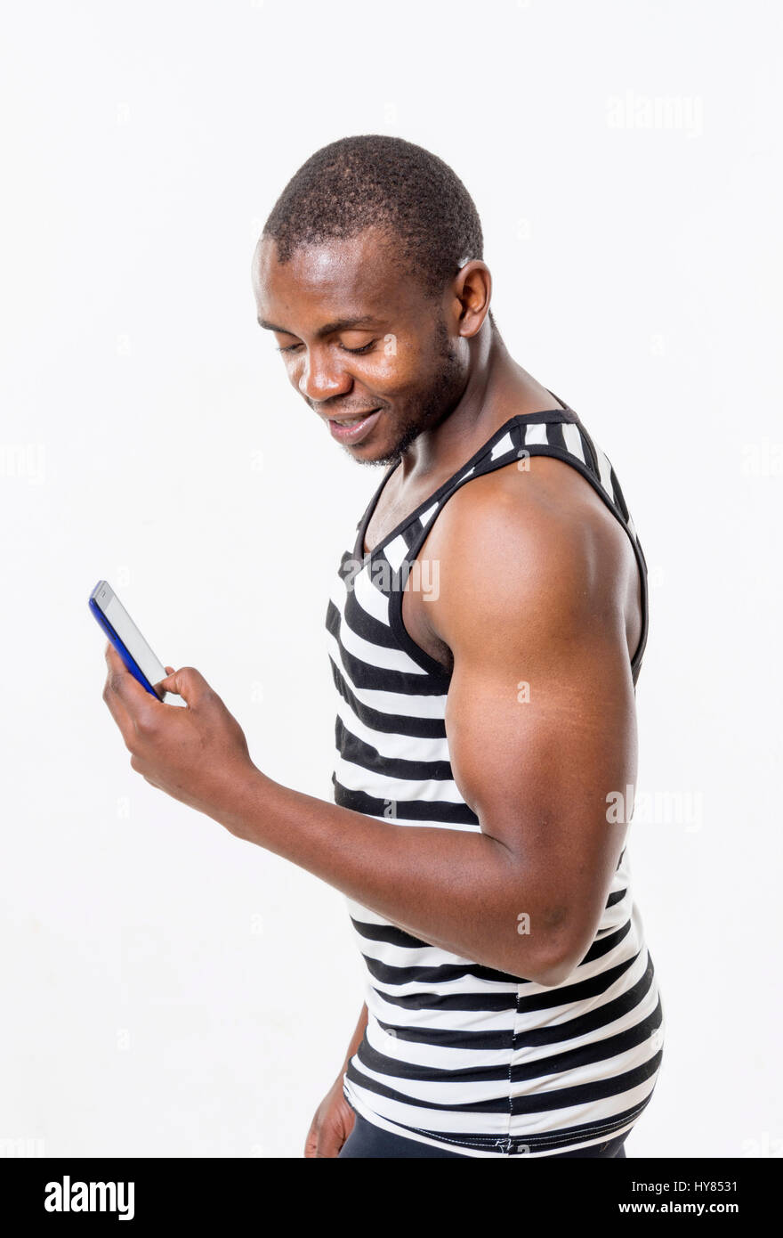 Ein Afrikaner benutzt ein Handy in einer Studioumgebung. Stockfoto