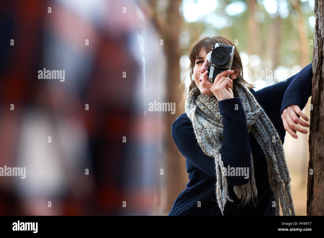 Eine Frau nimmt ein Foto von ihrem männlichen Begleiter, wie sie in den Wald gehen Stockfoto