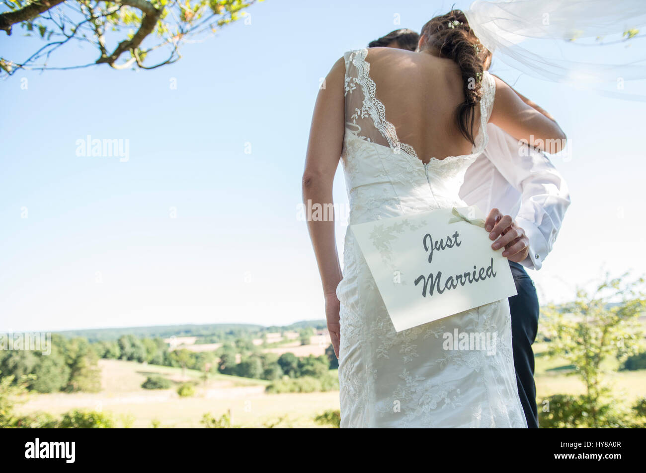 Eine Braut und Bräutigam halten ein Just Married Zeichen am Tag ihrer Hochzeit Stockfoto