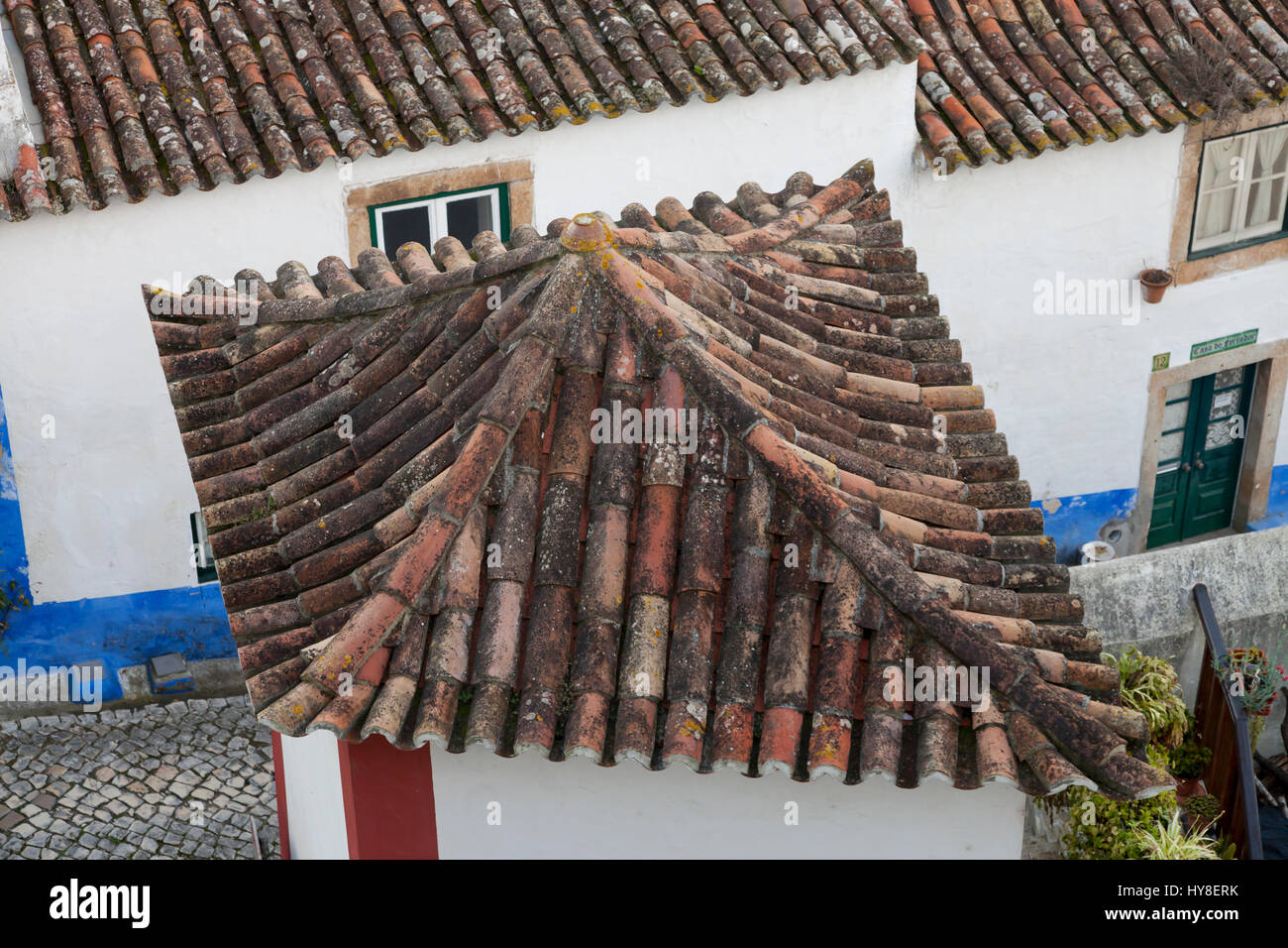 Óbidos, Portugal: Skurrile Terrakotta Dach auf ein Haus im alten Dorfkern. Stockfoto