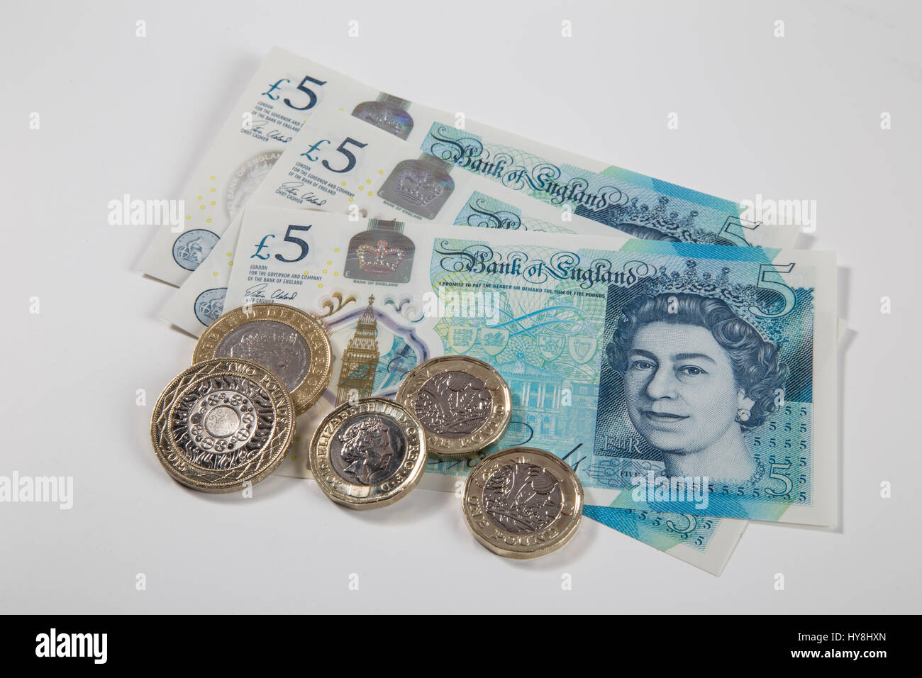 Neue £1-Pfund-Münzen, £2-Pfund-Münzen und £5-Pfund-Banknoten. Alle britischen Ausschreibungen Stockfoto
