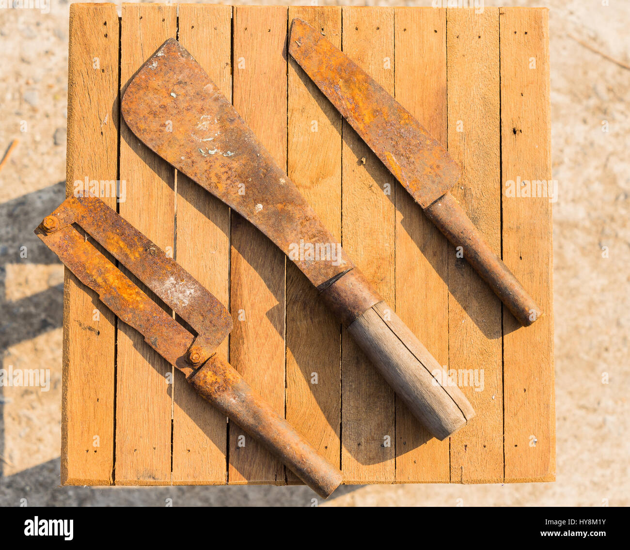Rostige Messer auf Holz-Fliesen, Bauer Geräte in Thailand, Top View Fleischerbeil mit Fleischermesser Stockfoto