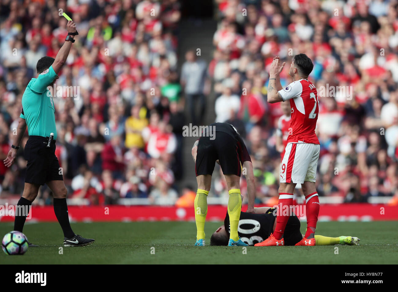 Arsenals Granit Qualifikationsspiel erhält eine gelbe Karte von Schiedsrichter Andre Marriner während der Premier-League-Spiel im Emirates Stadium, London. Stockfoto