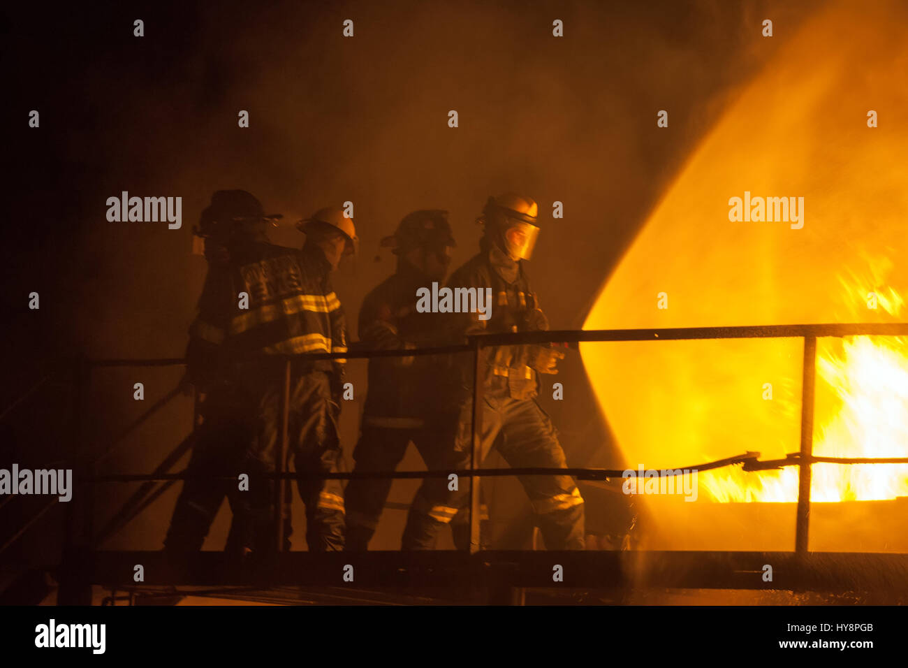 Feuerwehrleute mit voller Spray, löschte Feuer während der Brandbekämpfung Übung Stockfoto