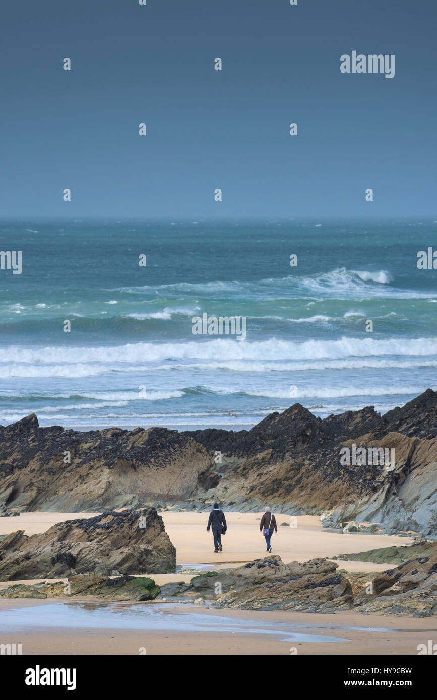Paar zu Fuß Spaziergang bummeln Strand Küste am Meer Meer rockt felsigen Wellen surfen rauen windigen zerklüftete Küste Küste Fistral Cornwall Stockfoto