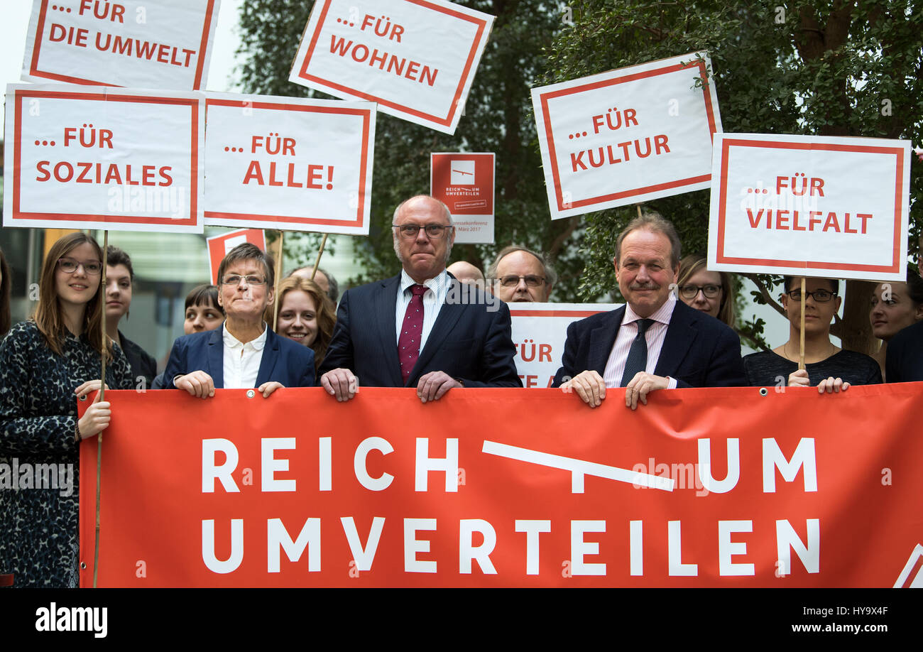 Barbara Eschen, Sprecher der National Conference in Armut ("Nationale Armutskonferenz") und Leiter der Diakonie Berlin-Brandenburg-Schlesische Oberlausitz, Ulrich Schneider, Vorstandsvorsitzender Der Paritaetische Gesamtverband (lit.) "Die Parität Allgemeine Vereinigung"), und Frank Bsirske, Vorsitzende der Gewerkschaft Verdi stehen zusammen nach einer Pressekonferenz auf die Forderungen des Bündnisses "Reichtum Umverteilen" (lit.) "Verteilen Sie Reichtum") von den politischen Parteien im allgemeinen Wahlkampf hinter ein Banner auf einer Demonstration in Berlin, Deutschland, 28. März 2017. Foto: Bernd von Jutrczenka / Stockfoto