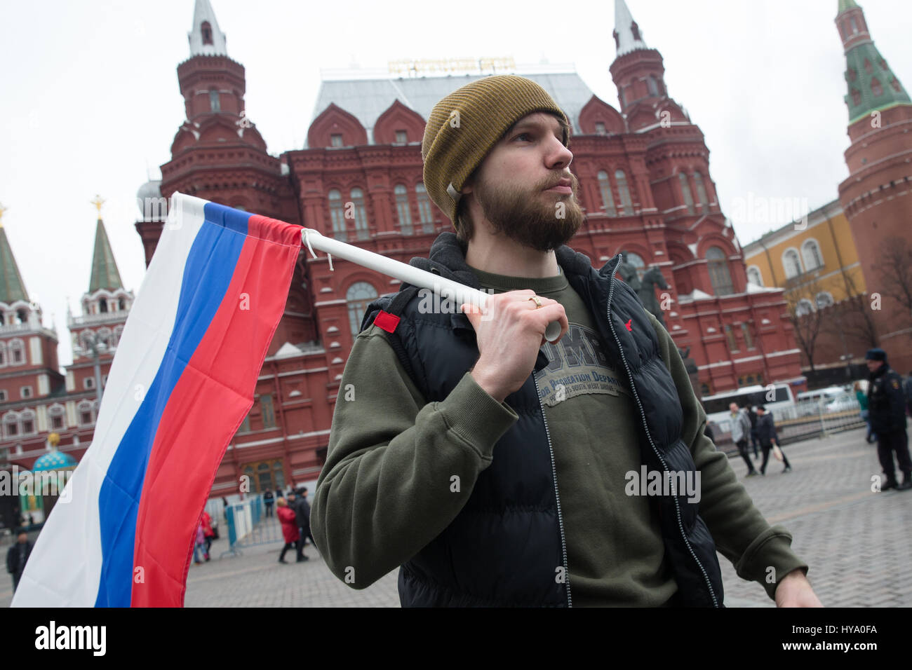 Moskau, Russland. 2. April 2017. Ein Mann geht mit einer russischen nationalen Flagge vor dem historischen Museum nahe dem Roten Platz in Moskau. Russische Staatsanwaltschaft zog Freitag, Anrufe in sozialen Netzwerken für mehr Straßenproteste in Moskau und anderen russischen Städten nach einer Welle von Demonstrationen zu blockieren. Bildnachweis: Victor Vytolskiy/Alamy Live-Nachrichten Stockfoto