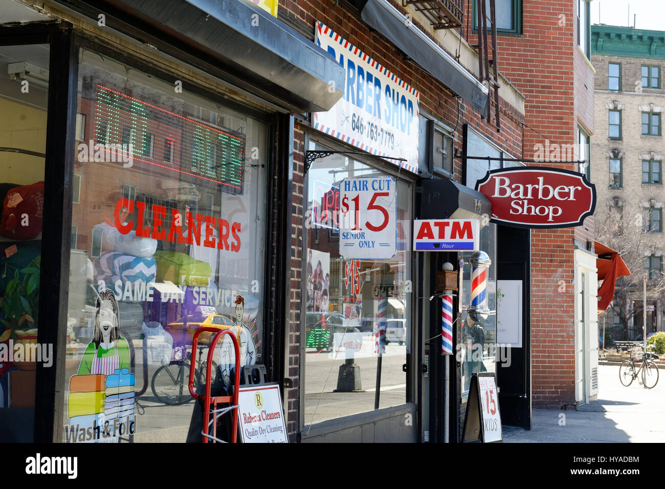 Eine Reinigung und eine altmodische Friseur gehören zu den Geschäften an der Seventh Avenue im Greenwich Village, Manhattan. 29. März 2017 Stockfoto