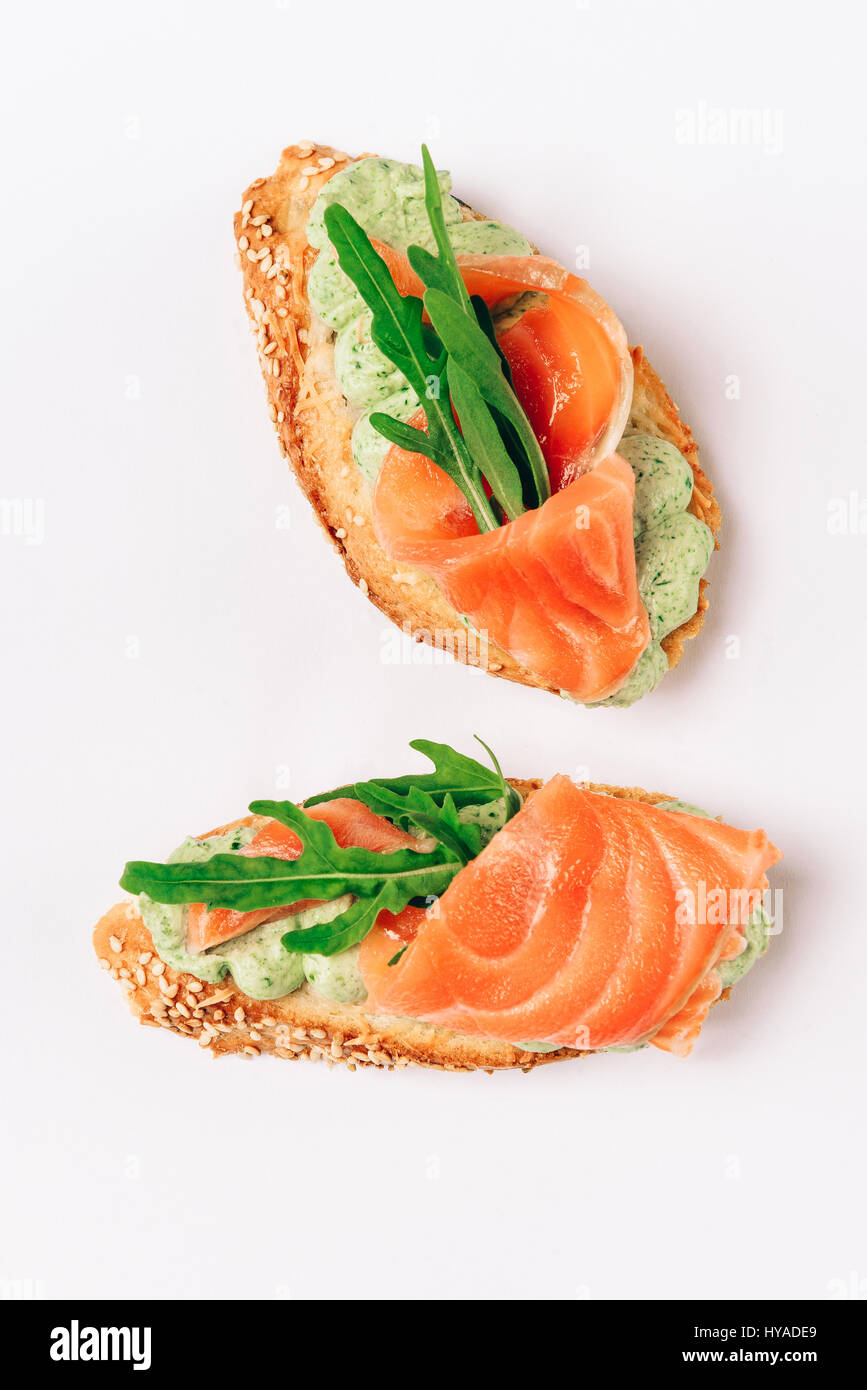 Zwei Bruschettes mit Rucola in Filet vom Thunfisch und grüner sauce Stockfoto