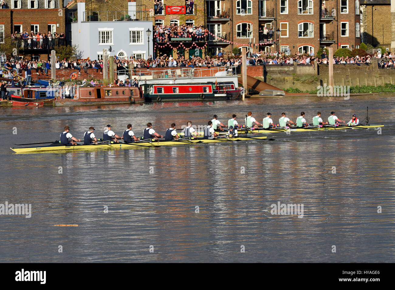 University Boat Race Oxford gegen Cambridge on the Themse in Barnes, London. Die Leute beobachten das Boot, während sie vorbeifahren Stockfoto
