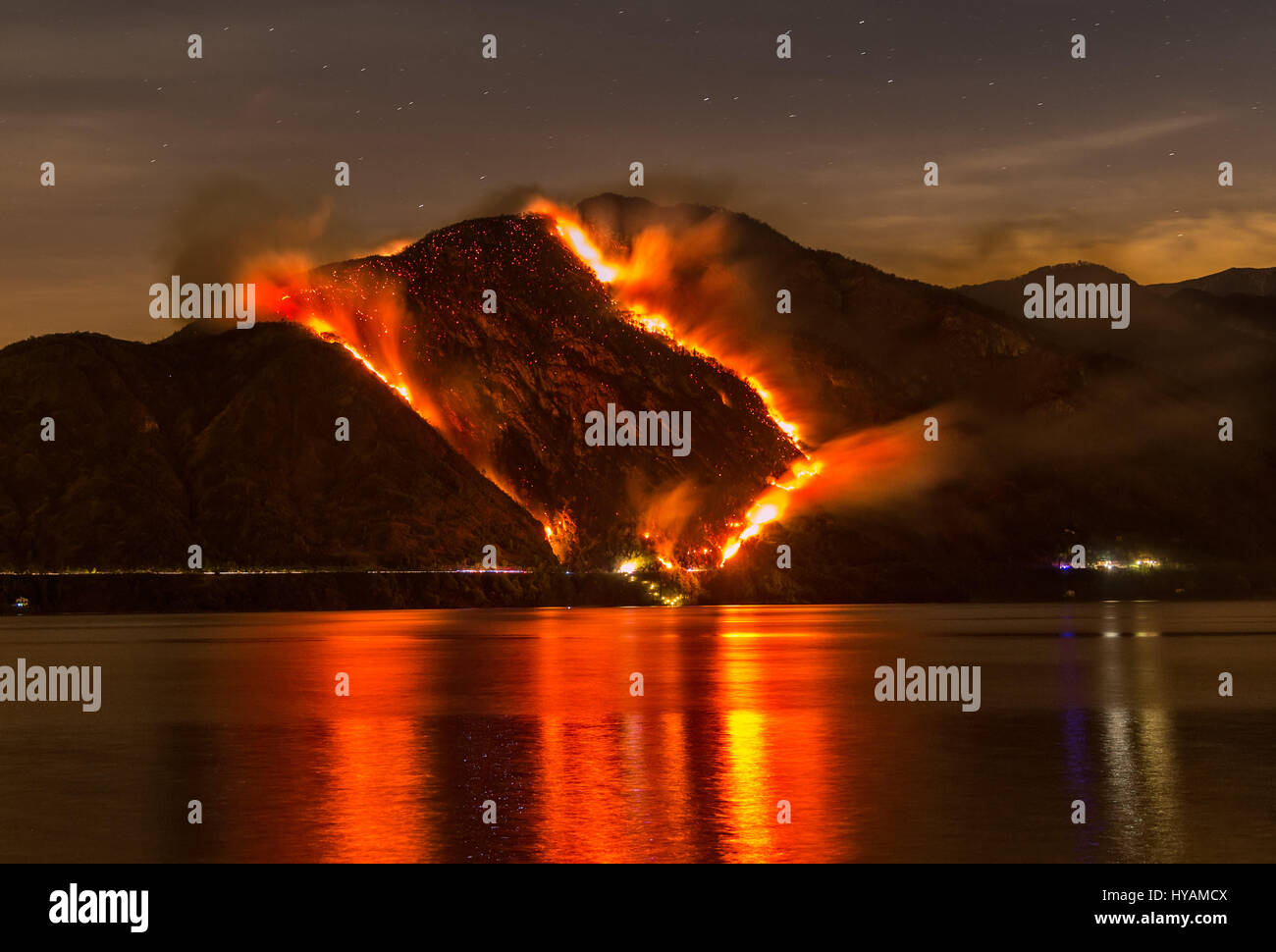 SPEKTAKULÄRE Bilder zeigen einen Berg verschlungen im Feuer sowie die Notfall Luft Bemühungen, es zu löschen. Italienischen Zivilschutz Feuerwehr Flugzeug namens Canadair stundenlang 30 kämpfen um ein Feuer zu löschen, die schließlich mit 2.000 Hektar Land, Eiche, Hainbuche und Buche zu zerstören. Garten Kuratorin nahm Alfredo Costanzo (49) die dramatischen Aufnahmen in Tremezzo in der italienischen Provinz Como, wo das Feuer, welche Experten glauben, bewusst gestartet wurde, war eines der schlechtesten in 20 Jahren. Stockfoto