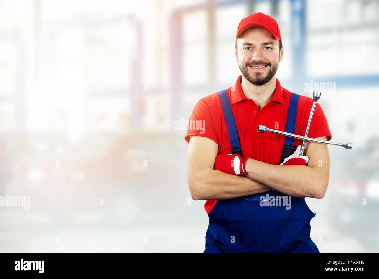 Auto-Reparatur-Service - Kfz-Mechaniker mit Schraubenschlüssel in der hand lächelnd Stockfoto