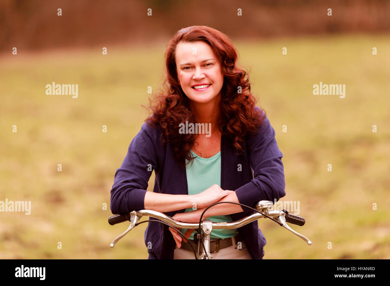 Porträt einer Frau mittleren Alters genießen die warmen Frühlingstage am Fahrrad Stockfoto