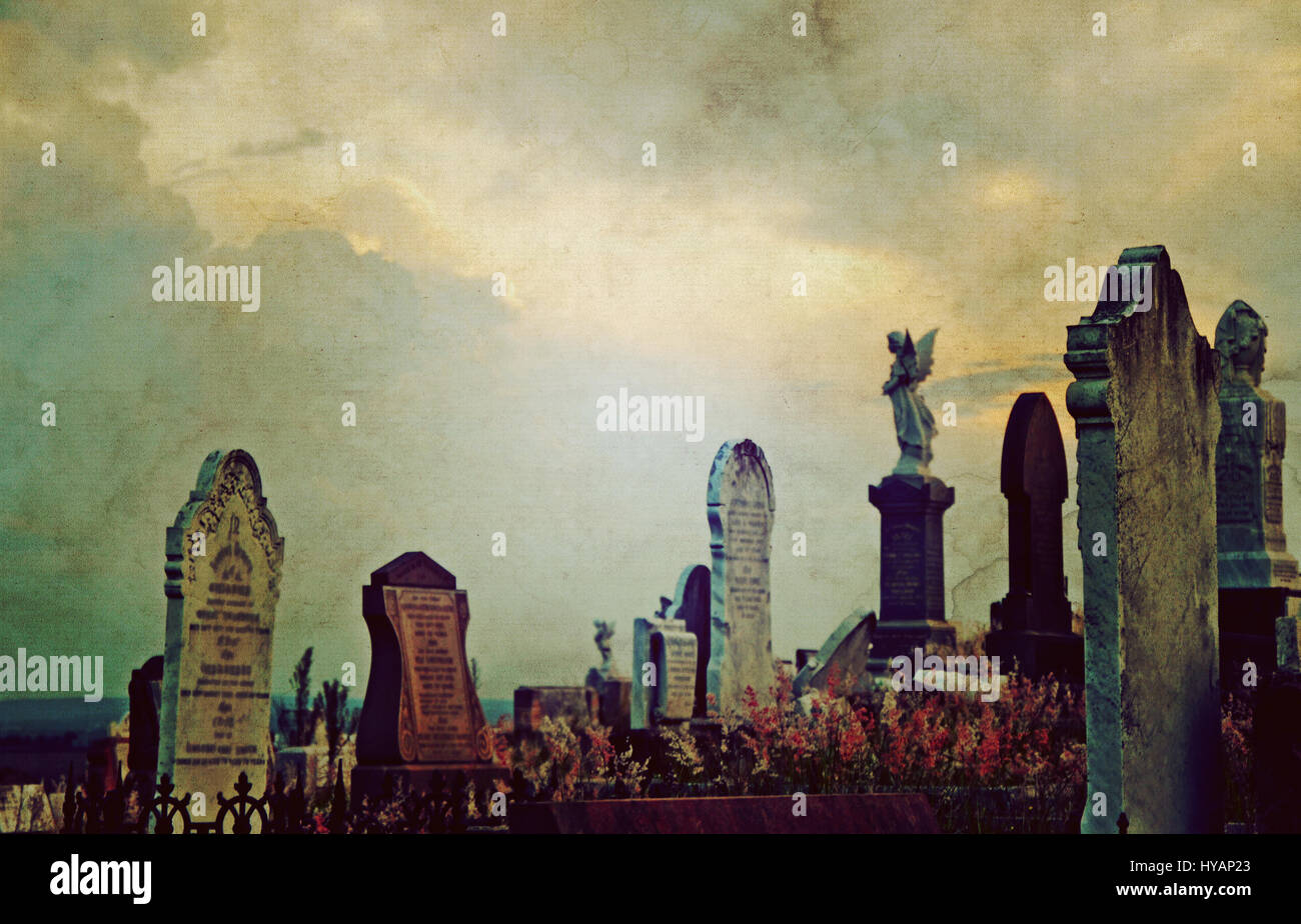 Gotische Friedhof Landschaft in der Dämmerung mit alten Grabsteinen und Engel unter einem dramatischen, hellen Himmel. Vintage Grunge strukturiertes Bild. Selektiven Fokus. Stockfoto