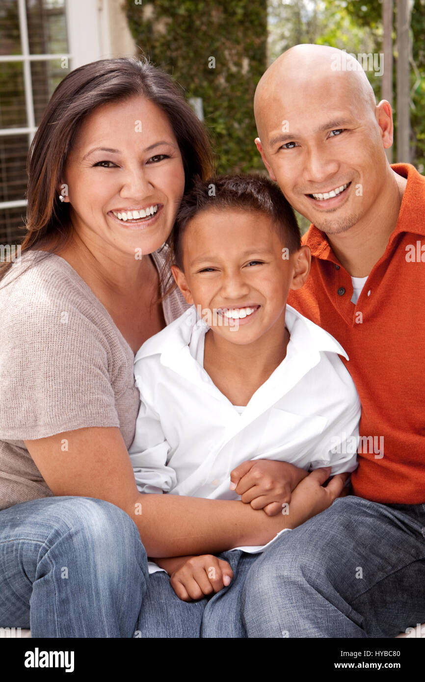 Porträt einer glücklichen asiatischen Familie draußen zu sitzen. Stockfoto