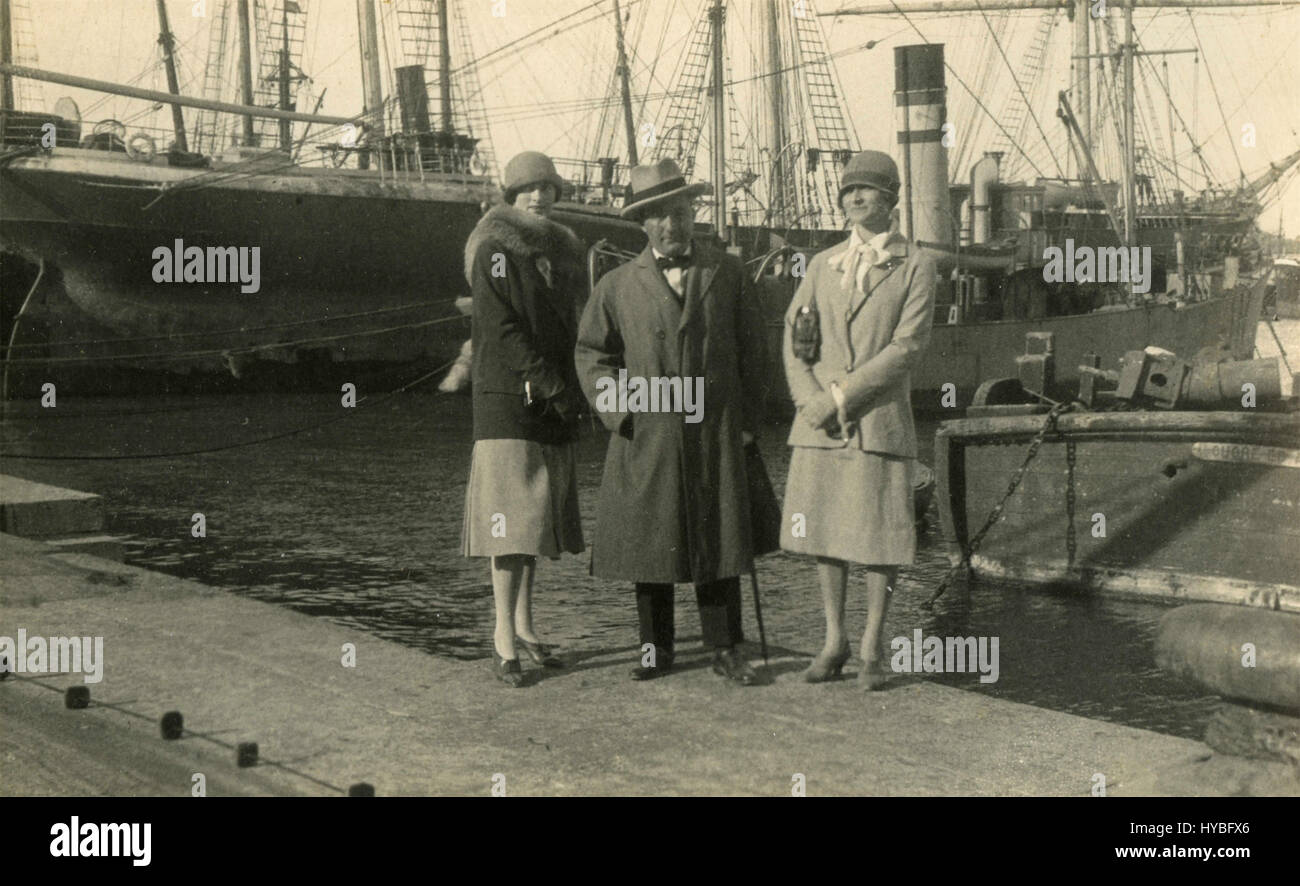 Zwei Frauen und ein Mann am Kai des Hafens, Italien Stockfoto