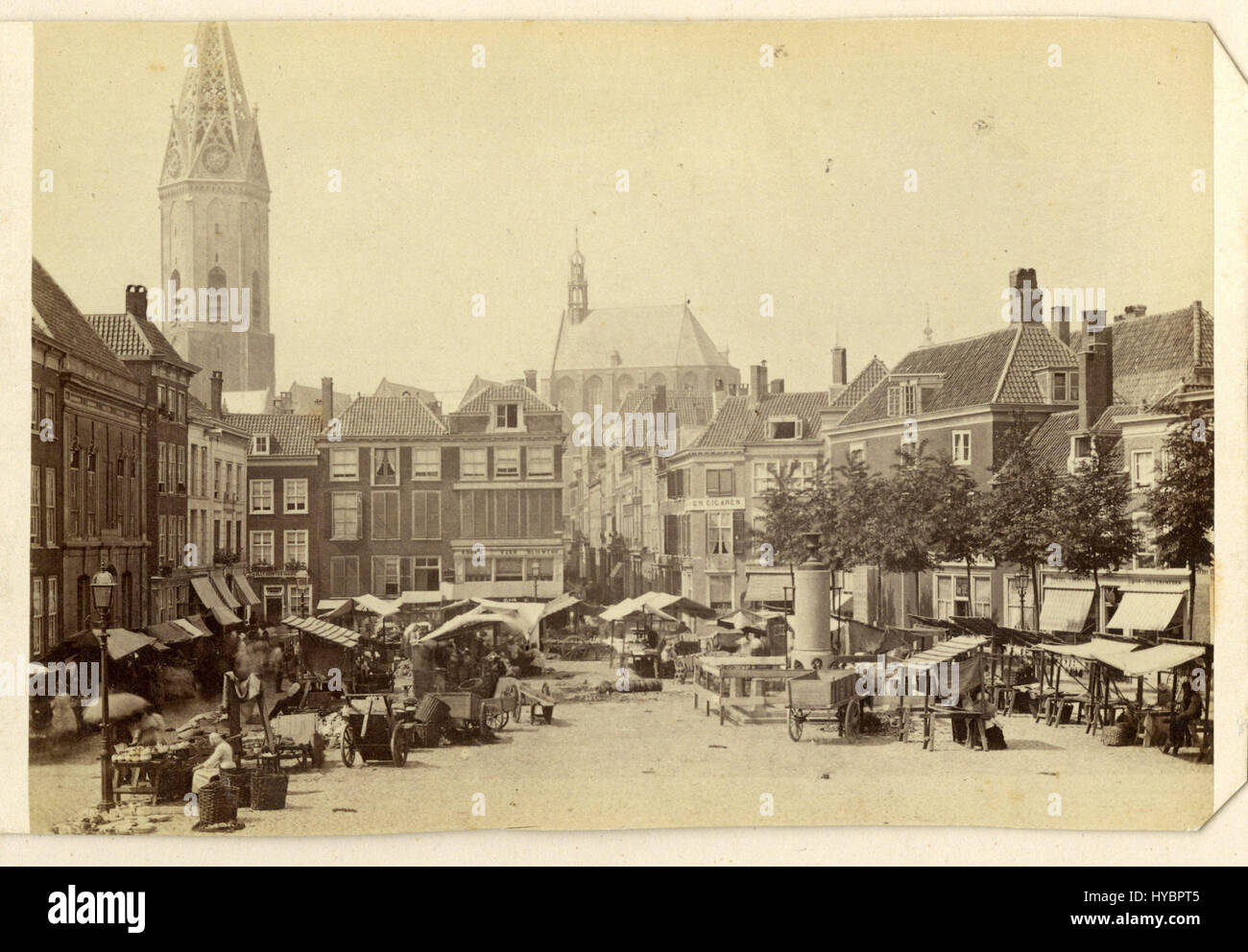Das Gemälde „Grote Markt, den Haag“ aus dem Jahr 1870 fängt eine geschäftige Szene des zentralen Platzes in den Haag, Niederlande, ein und zeigt seine Architektur und lebhafte Atmosphäre im späten 19. Jahrhundert. Stockfoto