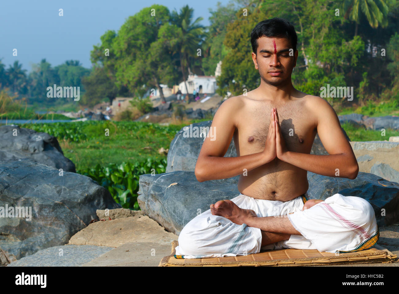 Indischer Mann üben Yoga Meditation an einem Fluss im Süden von Indien. Stockfoto