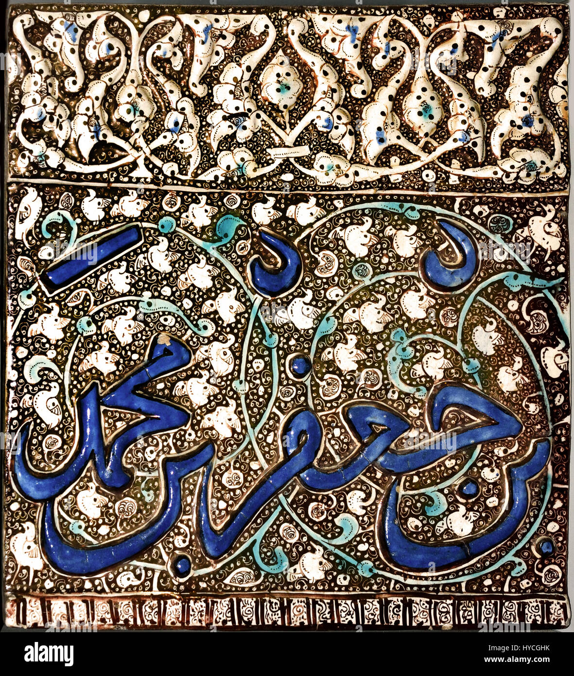 Mongol Glanz Fliesen 1310 Kashan - Ilchane Dynastie (Asien, Iran, Zentraliran, Isfahan) rechteckige Fries Fliese. blau, Türkis und Glanz über eine undurchsichtige weiße Glasur. Am obere Rand ist dekoriert mit einer Bandbreite von Lotus und Pfingstrose Blüten auf einem lustred Hintergrund mit Spiralen eingeschnitten. Das Hauptregister trägt Teil einer Inschrift (mit Datum) in geformten Relief, gemalt in blau vor dem lustered Hintergrund eines foliate ranken. Die schmale untere Grenze gliedert sich in quadratische Fächer mit einem abstrakten Design. Einige Teile der Dekoration werden durch Spritzer von geschönten hervorgehoben. Stockfoto
