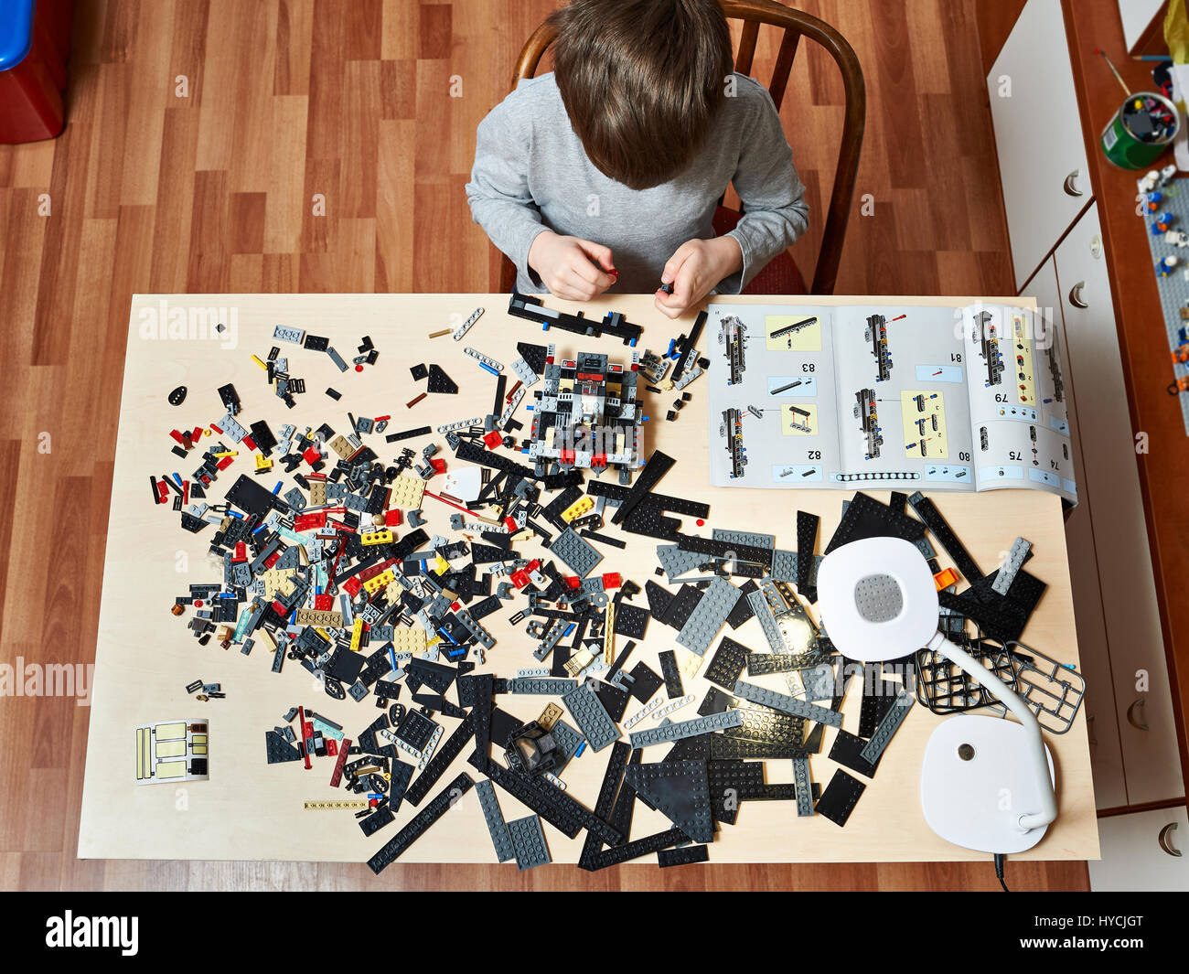 Kleiner Junge spielt und sammelt die Kinderspielzeug aus Kunststoff Stockfoto