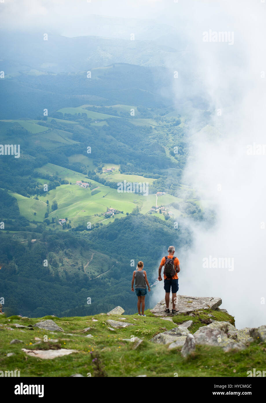 Mann und Frau Tourist paar stehen auf dem Gipfel des La Rune Berges Gipfel mit Blick auf atemberaubende Aussicht auf grüne Täler in den französischen Pyrenäen Stockfoto