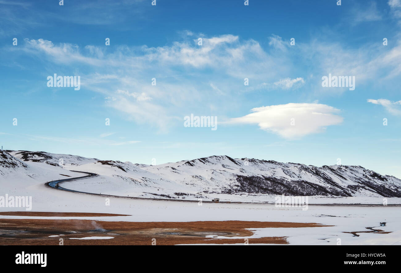 Landschaftlich im Winter mit Landstraße und linsenförmige Wolke am blauen Himmel Stockfoto