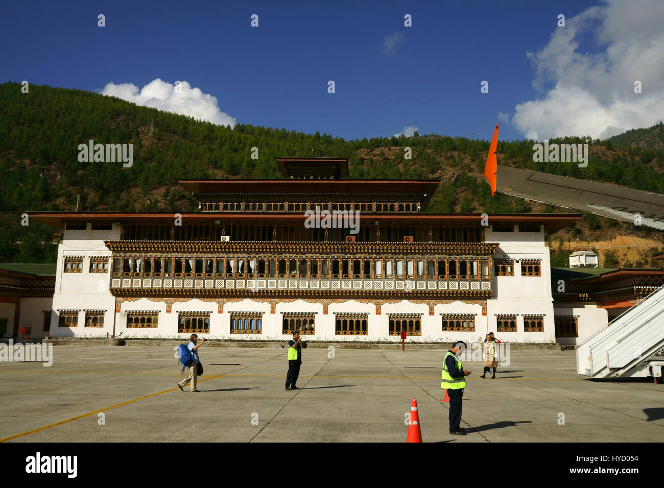 Flughafengebäude gesehen vom Rollfeld des Flughafens Paro, mit Angestellten und Menschen einsteigen Drukair Flugzeug, Bhutan Stockfoto
