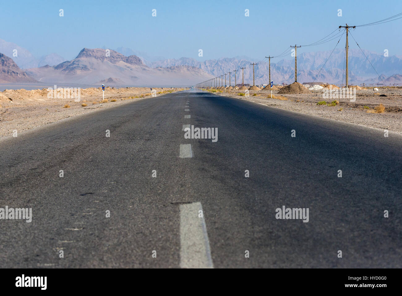 Gerade Asphaltstraße mit Bergen am Horizont in Yazd Provinz vom Iran Stockfoto