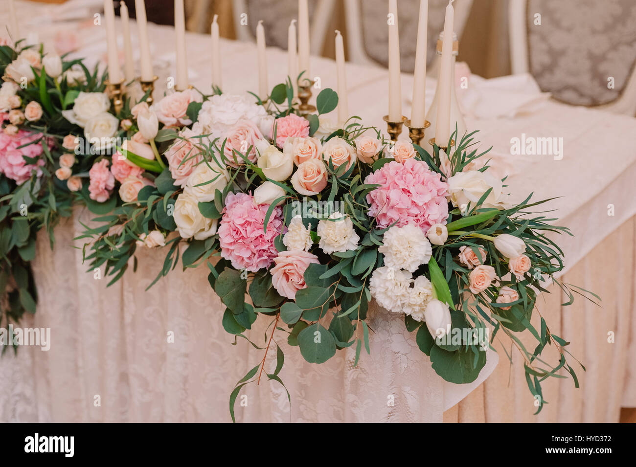 Hochzeit Tischdekoration mit Rosen, Nelken und Kerzen in der zart rosa  Lichtstil Stockfotografie - Alamy