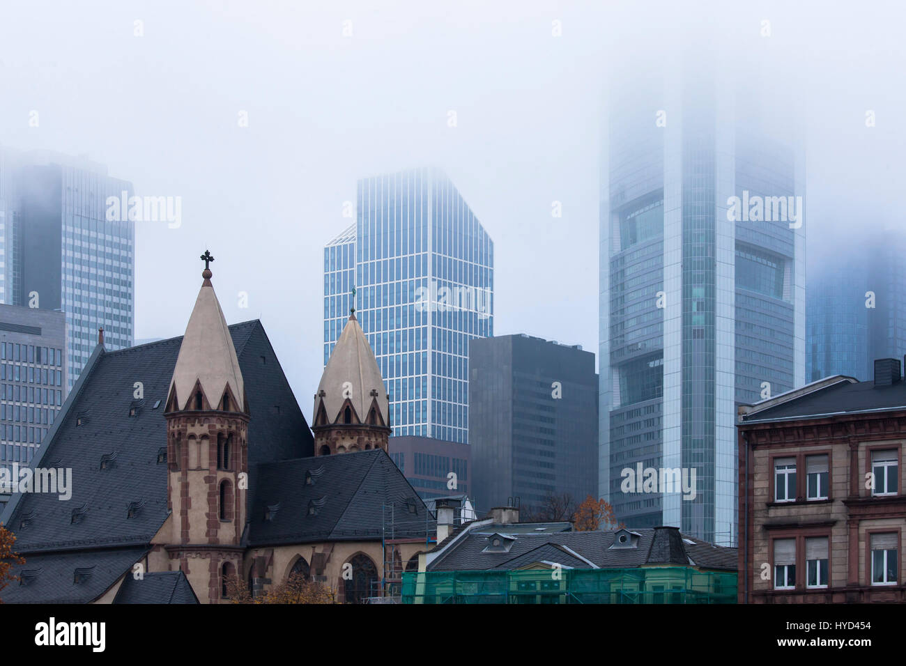 , Deutschland, Hessen, Frankfurt, St. Leonhards Kirche vor den Hochhäusern des Finanzviertels, Nebel. Stockfoto