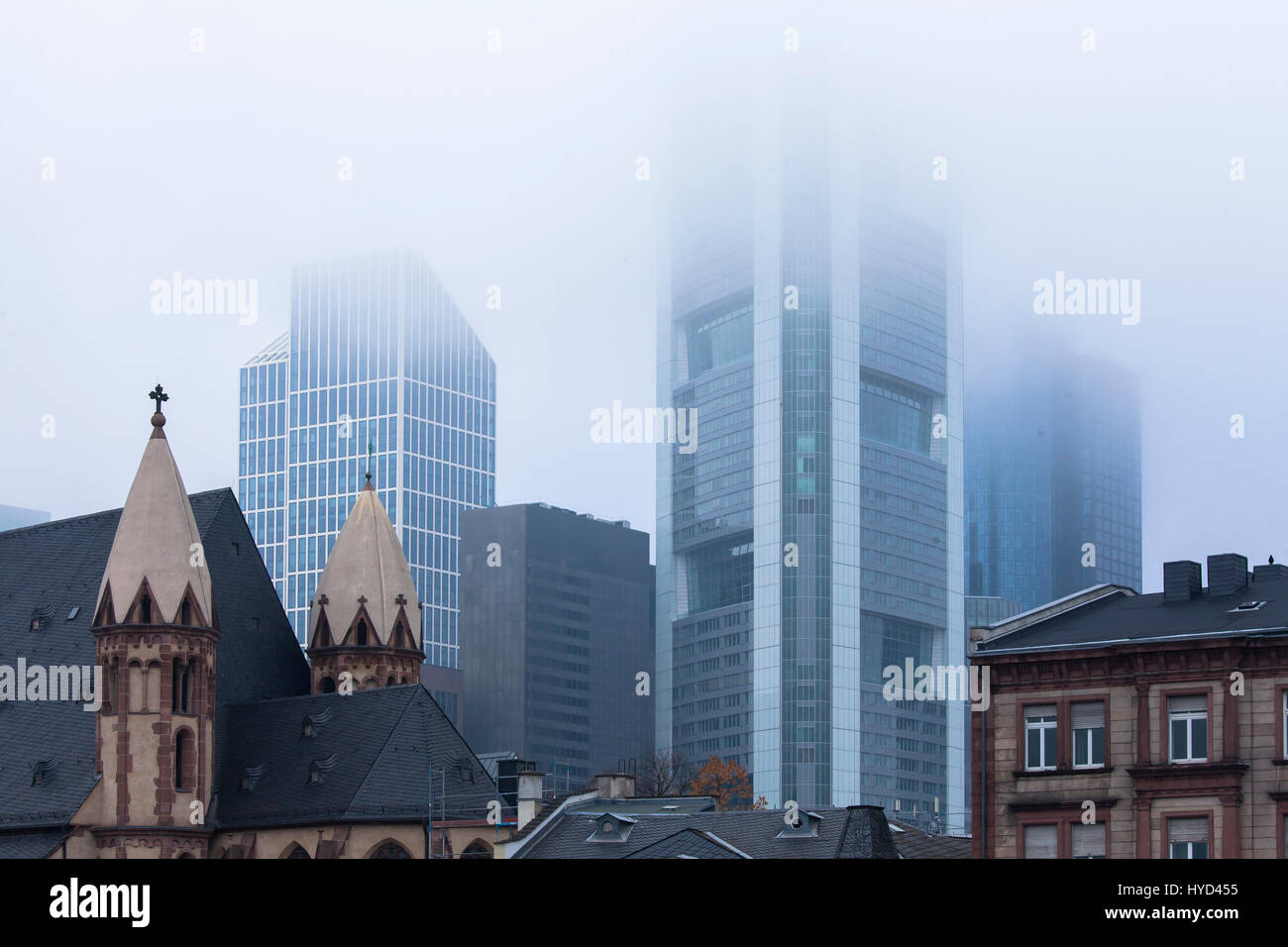 , Deutschland, Hessen, Frankfurt, St. Leonhards Kirche vor den Hochhäusern des Finanzviertels, Nebel. Stockfoto