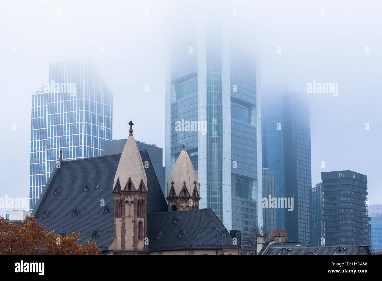 , Deutschland, Hessen, Frankfurt, St. Leonhards Kirche vor den Hochhäusern des Finanzviertels, Nebel. Stockfoto