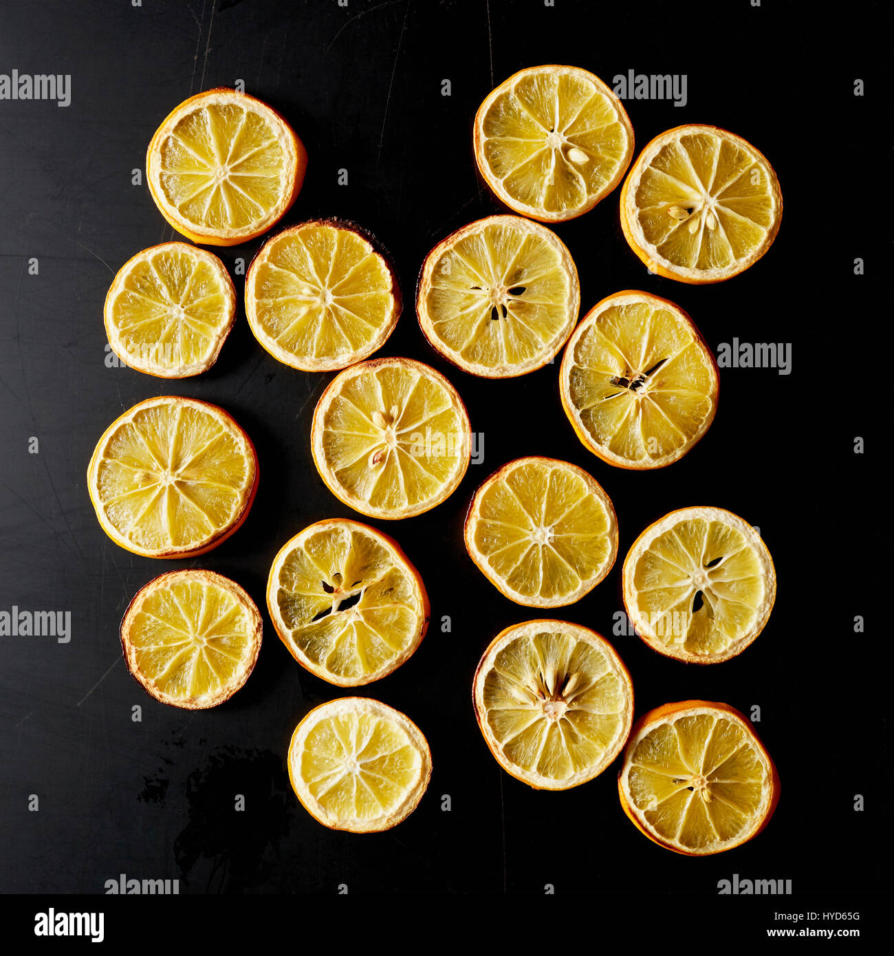 Getrocknete Zitronenscheiben auf schwarzem Hintergrund Stockfoto