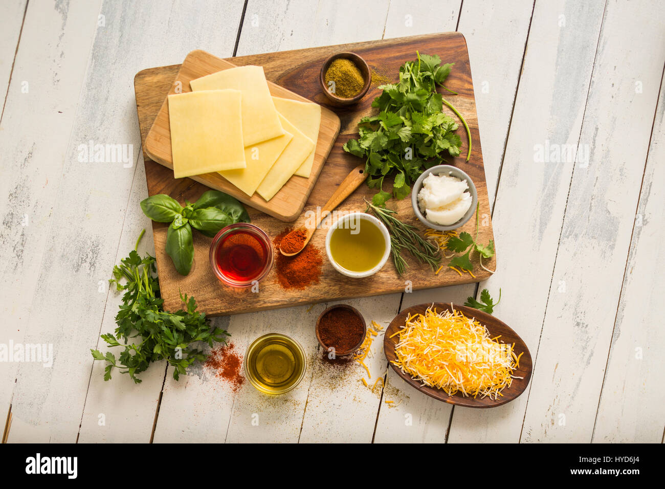 Käse, Kräuter und Gewürze auf Schneidebrett Stockfoto