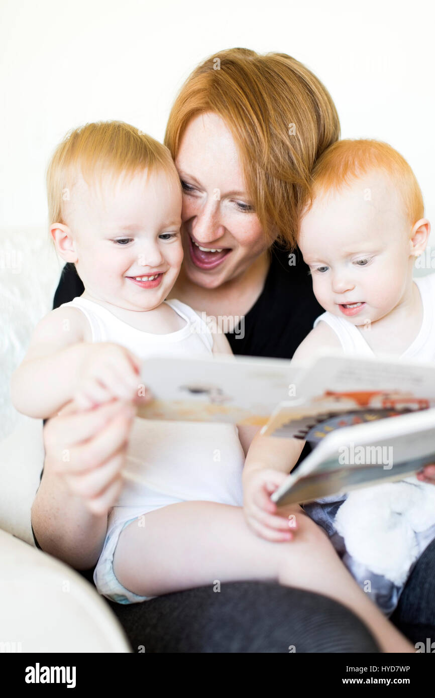 Mutter und Söhne (12-17 Monate) lesen Bilderbuch Stockfoto