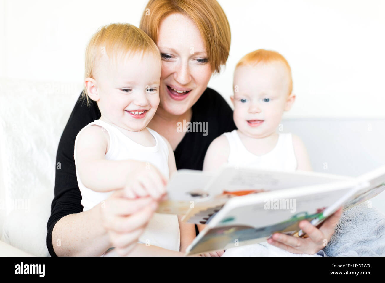 Mutter und Söhne (12-17 Monate) lesen Bilderbuch Stockfoto