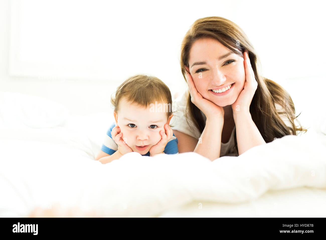 Mutter und Sohn (4-5) liegen auf dem Bett und lächeln Stockfoto