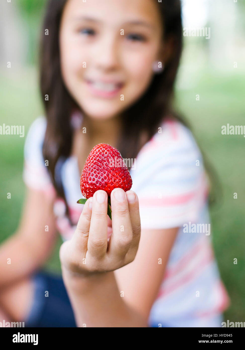 Mädchen (10-11) präsentiert Erdbeere Stockfoto