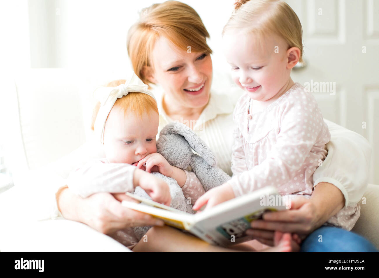 Mutter liest Buch an Töchter ( 12-17 Monate ) Stockfoto