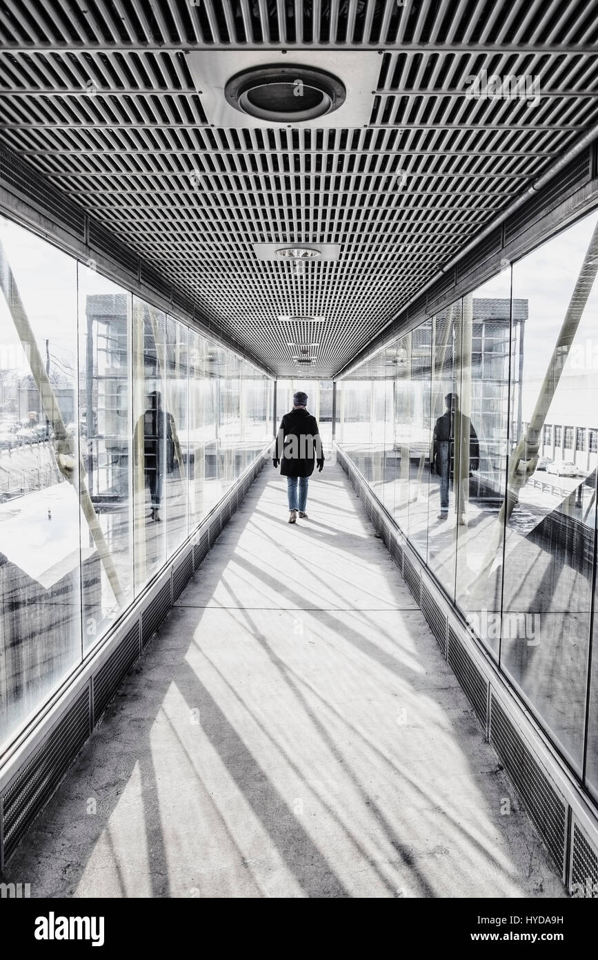 USA, MASSACHUSETTS, BOSTON, FRAU ZU FUß AUF ERHÖHTEN GLAS UND METALL GEHWEG AM BAHNHOF Stockfoto